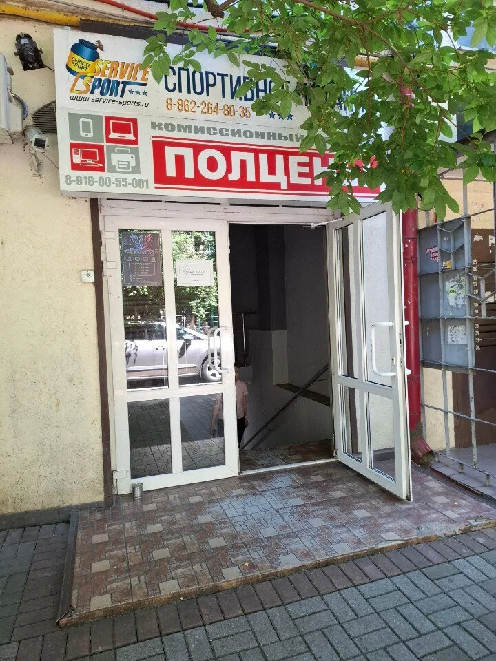 Вход в сервисный центр: белые двери под красной вывеской «Полцены»
